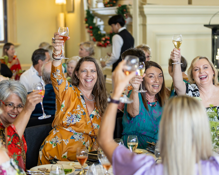 Three Glasses of Rose Cheering with Happy Woman in Background